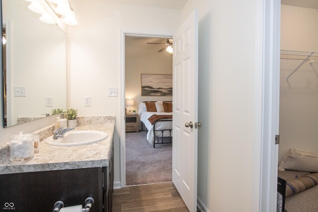 bathroom featuring vanity, ceiling fan, wood-type flooring, and lofted ceiling