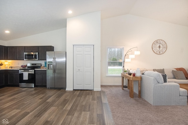 kitchen with appliances with stainless steel finishes, dark hardwood / wood-style flooring, and high vaulted ceiling