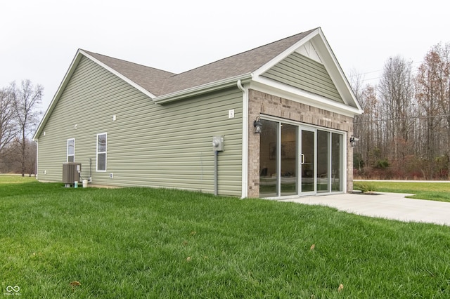 view of property exterior featuring central AC unit, a yard, and a patio