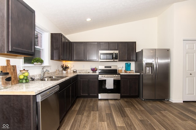 kitchen with sink, vaulted ceiling, dark hardwood / wood-style floors, appliances with stainless steel finishes, and dark brown cabinetry