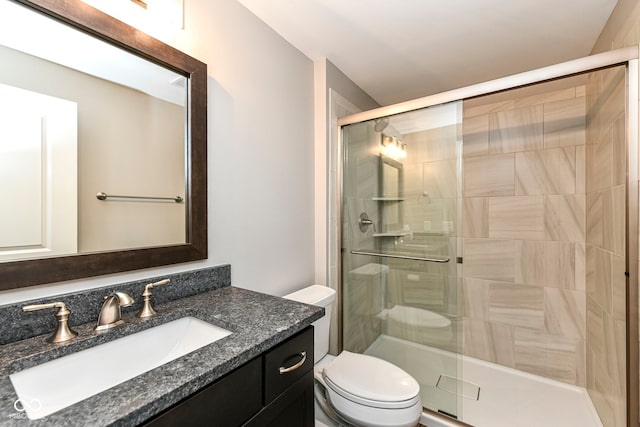 bathroom with a stall shower, vanity, and toilet