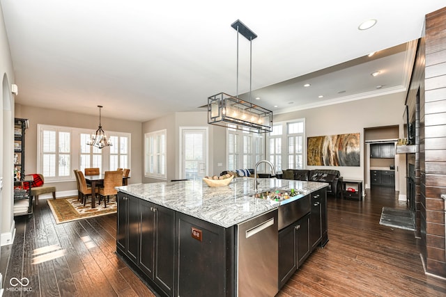 kitchen featuring an island with sink, hanging light fixtures, dark hardwood / wood-style floors, a chandelier, and light stone counters