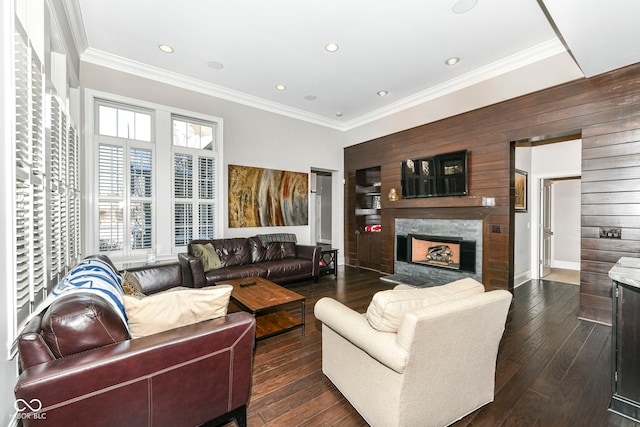 living room featuring a high end fireplace, dark wood-style flooring, crown molding, and recessed lighting