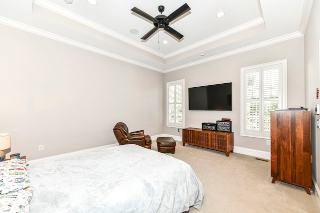 bedroom featuring ceiling fan, light colored carpet, a tray ceiling, and ornamental molding