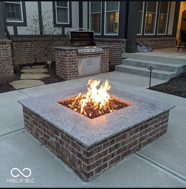 details with an outdoor fire pit and brick siding