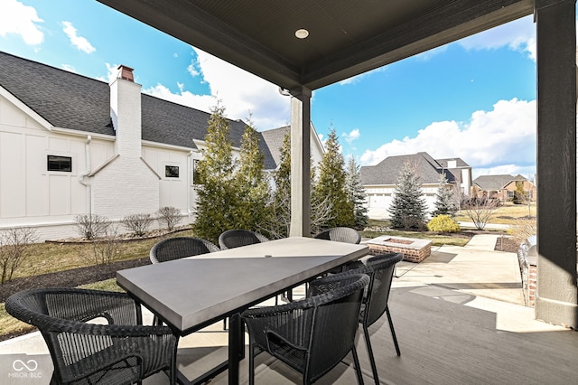 view of patio featuring outdoor dining space, a residential view, and a fire pit