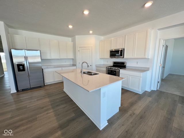 kitchen featuring a kitchen island with sink, sink, white cabinets, and appliances with stainless steel finishes