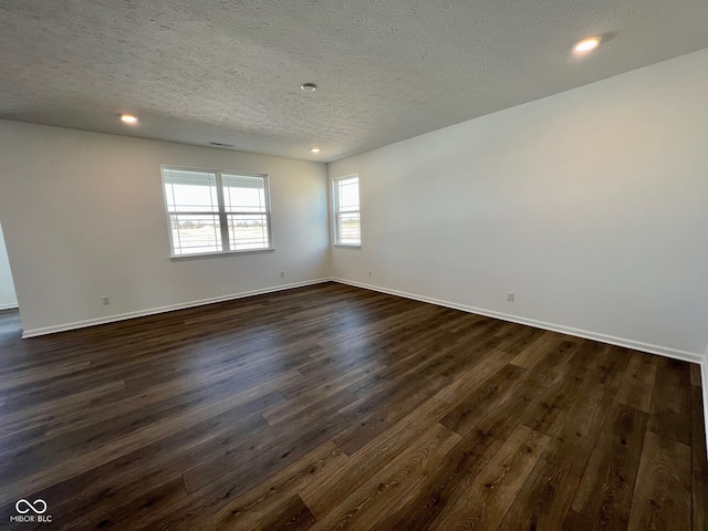 unfurnished room with dark hardwood / wood-style floors and a textured ceiling