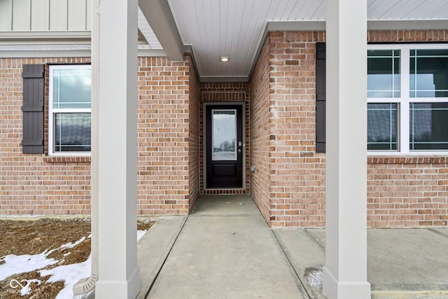 entrance to property with board and batten siding and brick siding