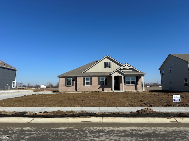 craftsman-style house featuring board and batten siding and brick siding