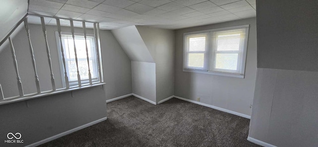 additional living space with dark carpet and lofted ceiling