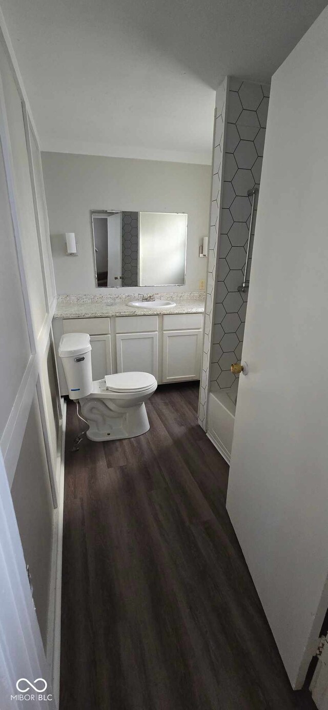 full bathroom featuring hardwood / wood-style floors, vanity, bathtub / shower combination, and toilet