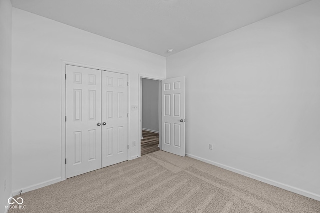 unfurnished bedroom featuring a closet and light colored carpet