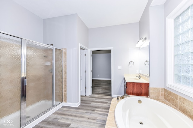 bathroom with plenty of natural light, vanity, wood-type flooring, and independent shower and bath