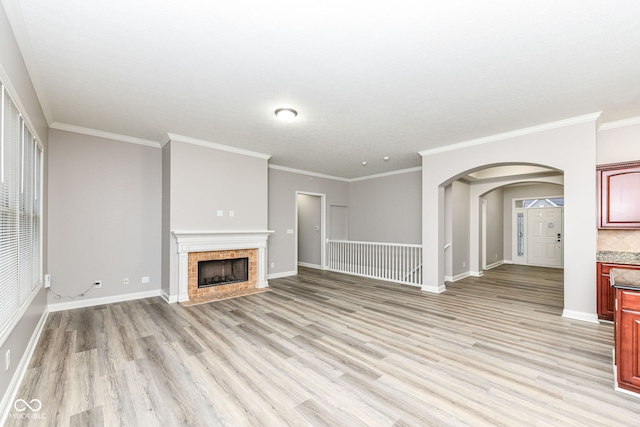 unfurnished living room with a fireplace, crown molding, and light hardwood / wood-style flooring