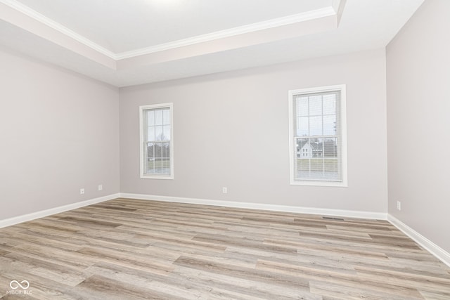 unfurnished room with ornamental molding, a healthy amount of sunlight, and light hardwood / wood-style floors