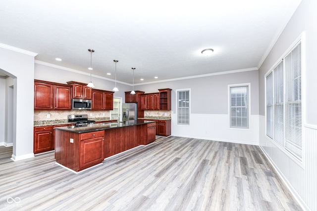 kitchen featuring stainless steel appliances, crown molding, pendant lighting, light hardwood / wood-style floors, and a kitchen island