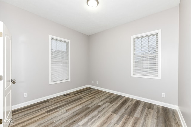 spare room featuring hardwood / wood-style flooring and a healthy amount of sunlight