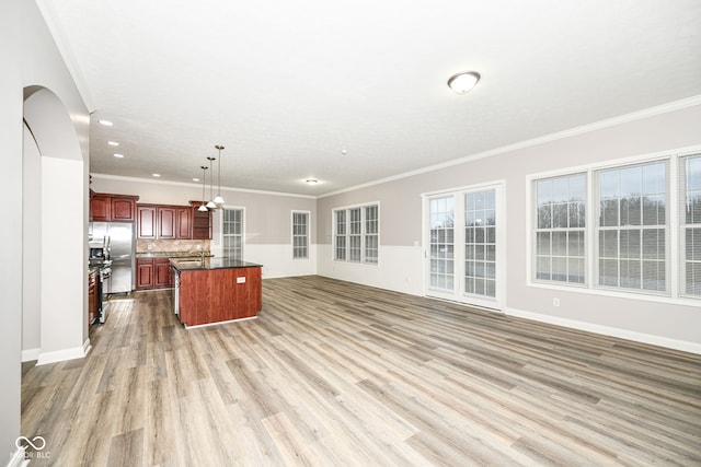 kitchen with decorative backsplash, ornamental molding, pendant lighting, a center island, and light hardwood / wood-style floors