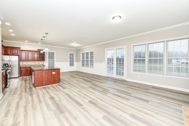 kitchen with crown molding, a center island, decorative light fixtures, and light wood-type flooring