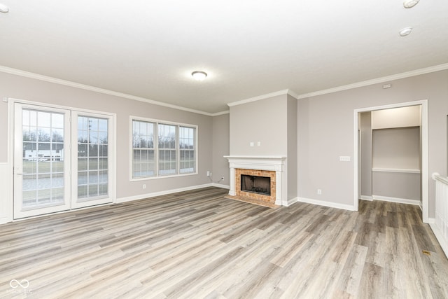 unfurnished living room featuring a tiled fireplace, light hardwood / wood-style flooring, and ornamental molding