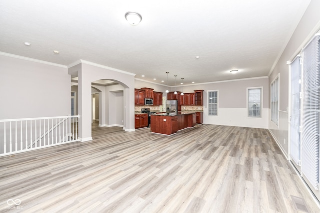 kitchen with stainless steel appliances, crown molding, decorative light fixtures, a kitchen island, and light wood-type flooring