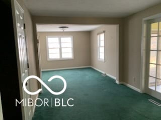 carpeted spare room featuring baseboards and visible vents