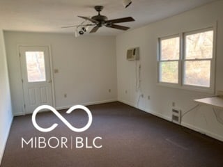 carpeted empty room with baseboards, a ceiling fan, and a wealth of natural light