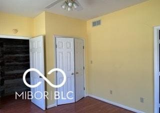 unfurnished bedroom with visible vents, wood finished floors, and baseboards