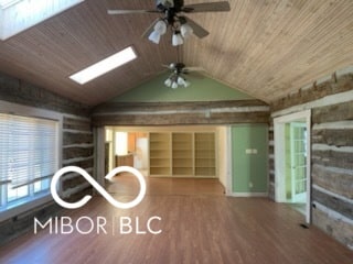 unfurnished living room with wood ceiling, wood finished floors, a ceiling fan, and vaulted ceiling with skylight