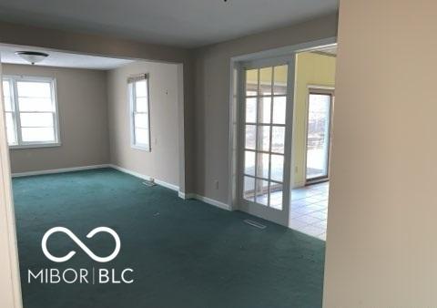 carpeted spare room with baseboards