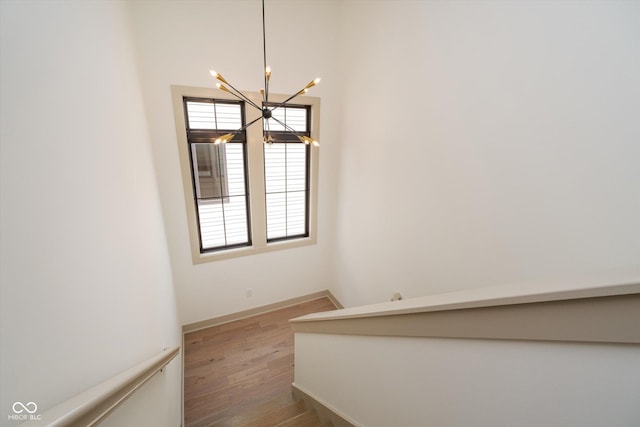 stairs with a notable chandelier and wood-type flooring