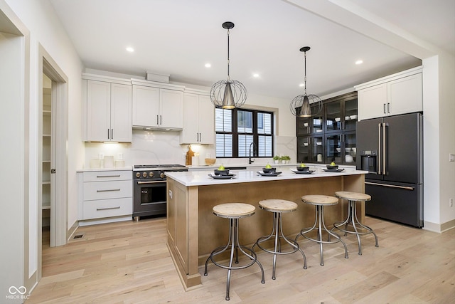 kitchen featuring high quality appliances, white cabinets, and a center island