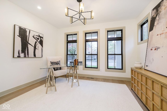 sitting room featuring a chandelier and light wood-type flooring