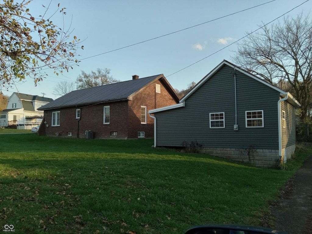 view of property exterior featuring a yard and central AC unit