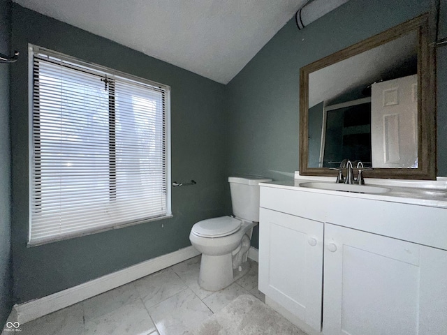 bathroom with lofted ceiling, vanity, and toilet