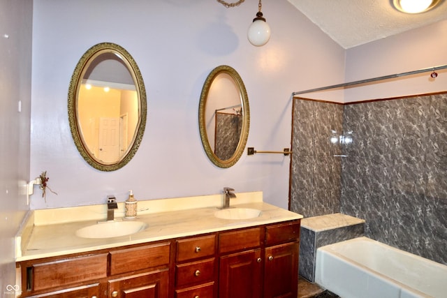 bathroom featuring a textured ceiling, tub / shower combination, and vanity