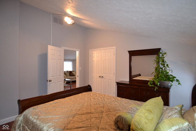 bedroom with lofted ceiling and a textured ceiling