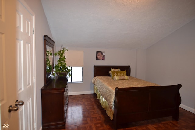 bedroom with a textured ceiling and dark parquet floors