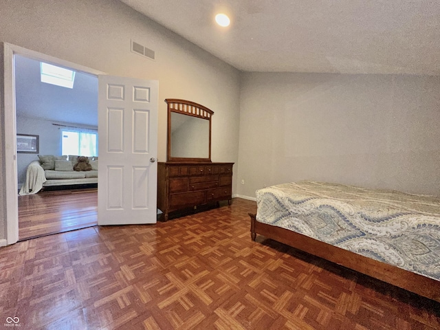 bedroom featuring lofted ceiling and parquet flooring