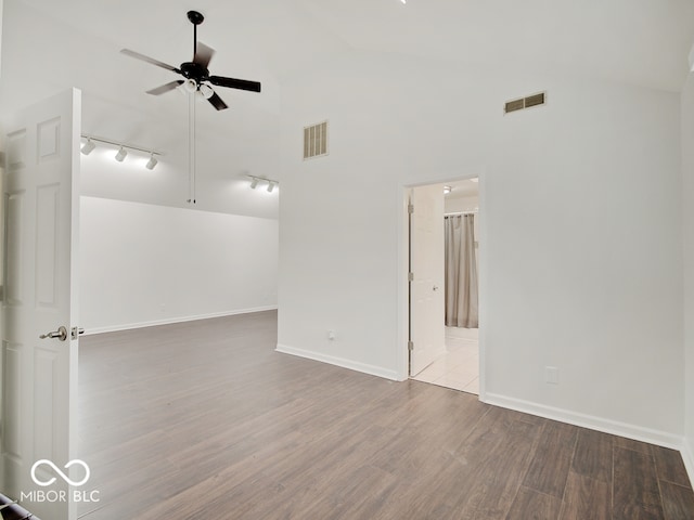 unfurnished room featuring high vaulted ceiling, ceiling fan, track lighting, and light hardwood / wood-style flooring