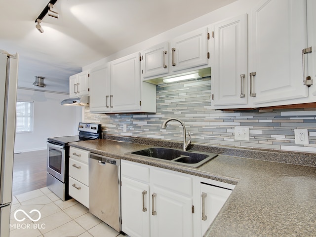 kitchen with white cabinetry, sink, tasteful backsplash, light tile patterned flooring, and appliances with stainless steel finishes