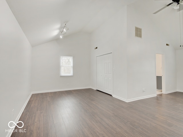 spare room featuring ceiling fan, rail lighting, dark hardwood / wood-style floors, and high vaulted ceiling