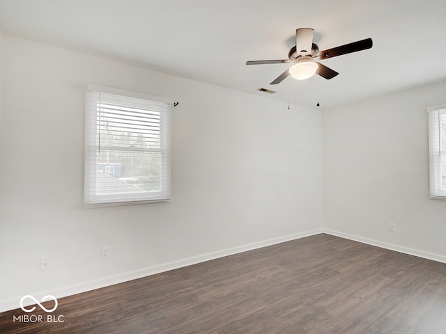 spare room featuring dark hardwood / wood-style flooring and ceiling fan