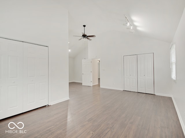 interior space with two closets, rail lighting, and light hardwood / wood-style floors