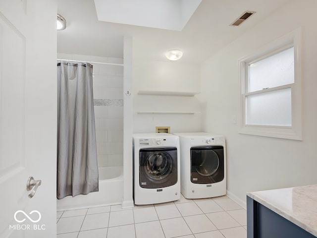 clothes washing area featuring separate washer and dryer and light tile patterned flooring