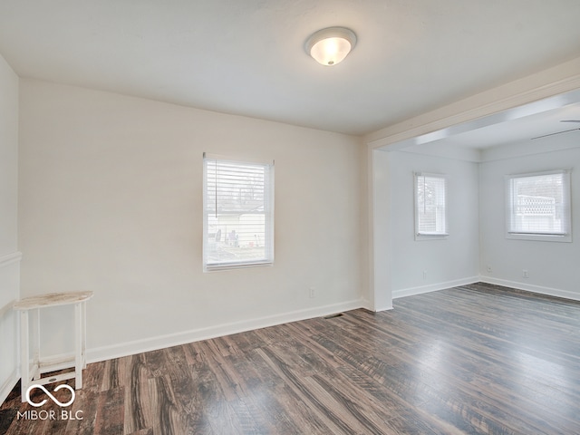 spare room with dark hardwood / wood-style floors and ceiling fan