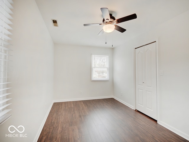 spare room with ceiling fan and dark wood-type flooring