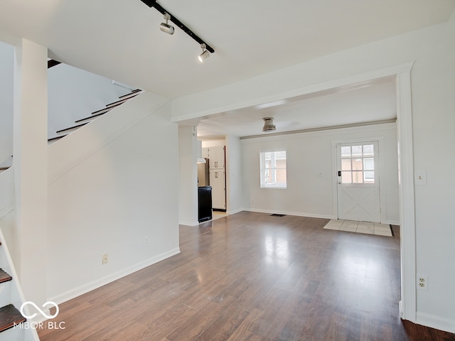 unfurnished living room with wood-type flooring and rail lighting