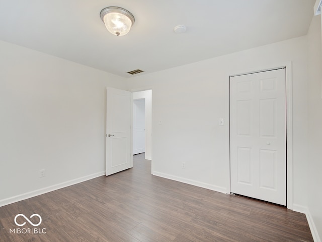 unfurnished bedroom with dark wood-type flooring